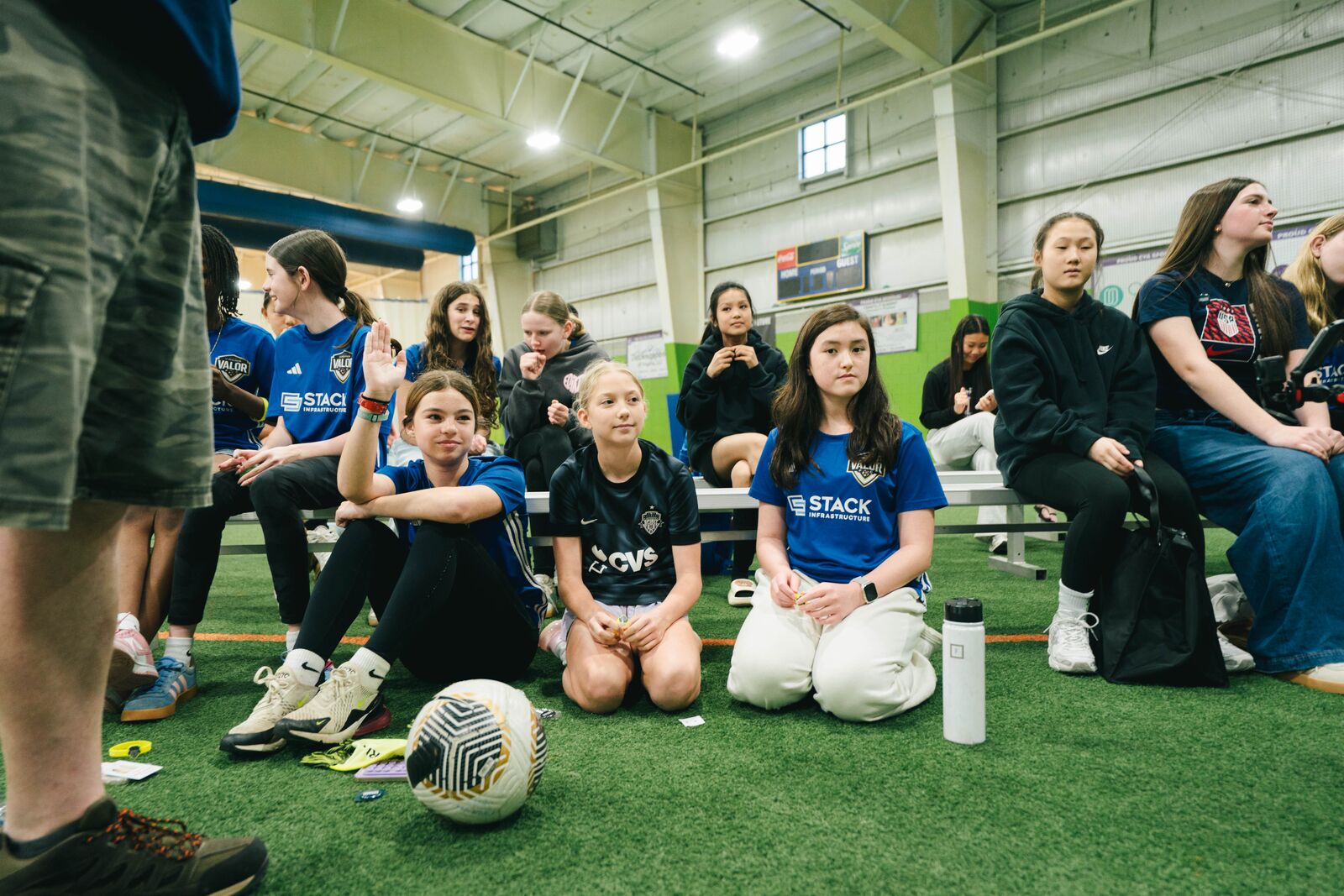 Young soccer players seated near the front of the live event at The Fieldhouse.