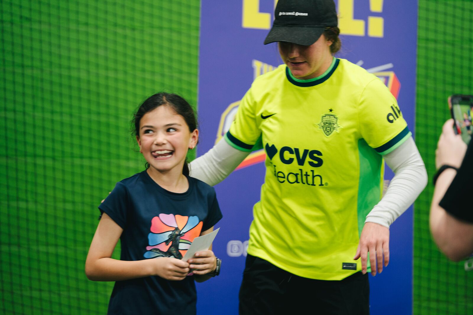 Kate Wiesner posing with a smiling young fan during the photo line at The Fieldhouse.